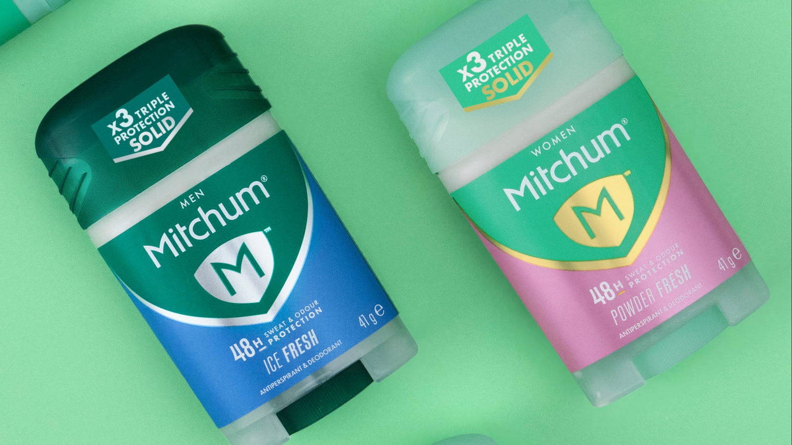 Two Mitchum deodorant sticks on a green background